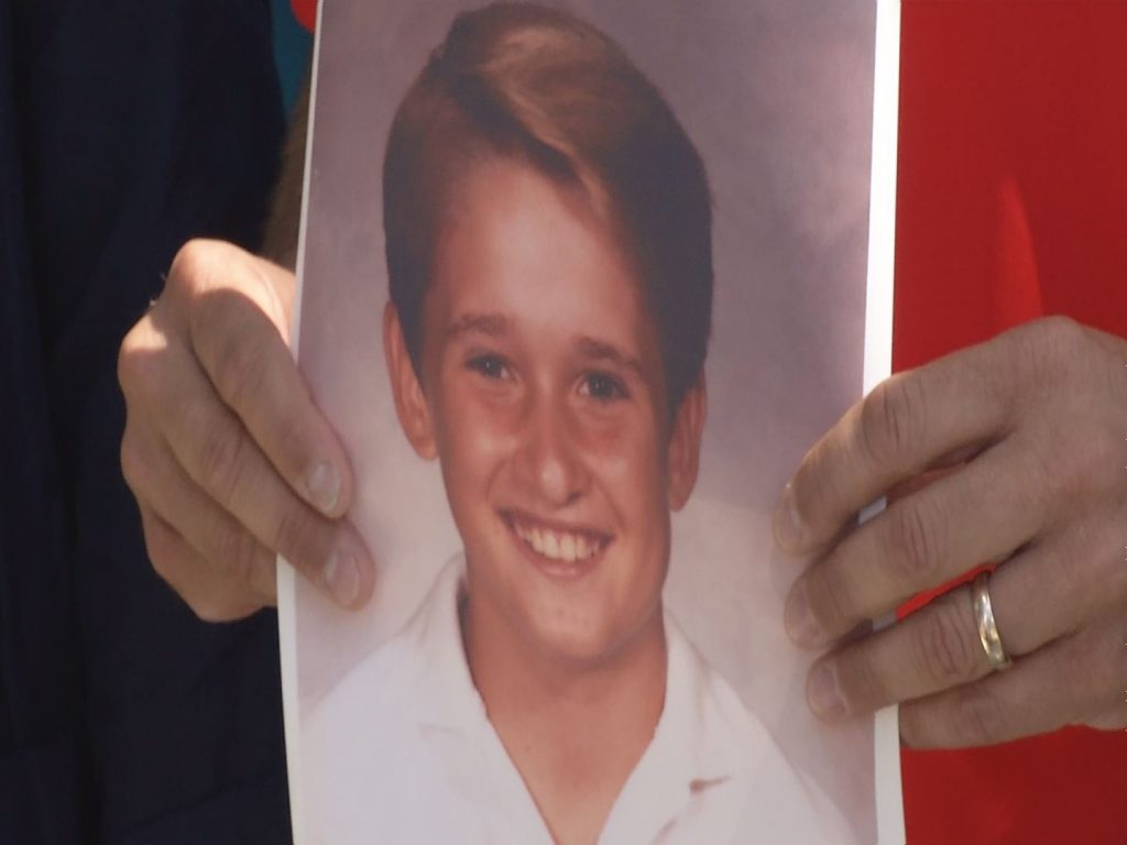 A man holding a picture of young Chris Templeton
